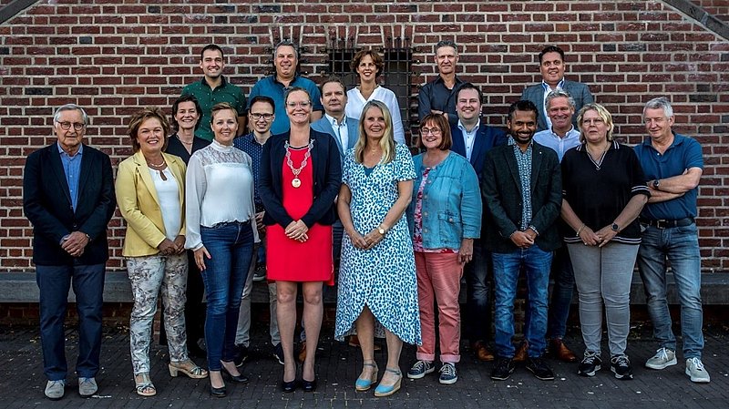 Foto met de leden van de gemeenteraad 2022-2026 voor het gemeentehuis van Asten
