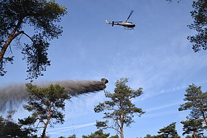 Helicopter tijdens het lozen van steenmeel van dichtbij